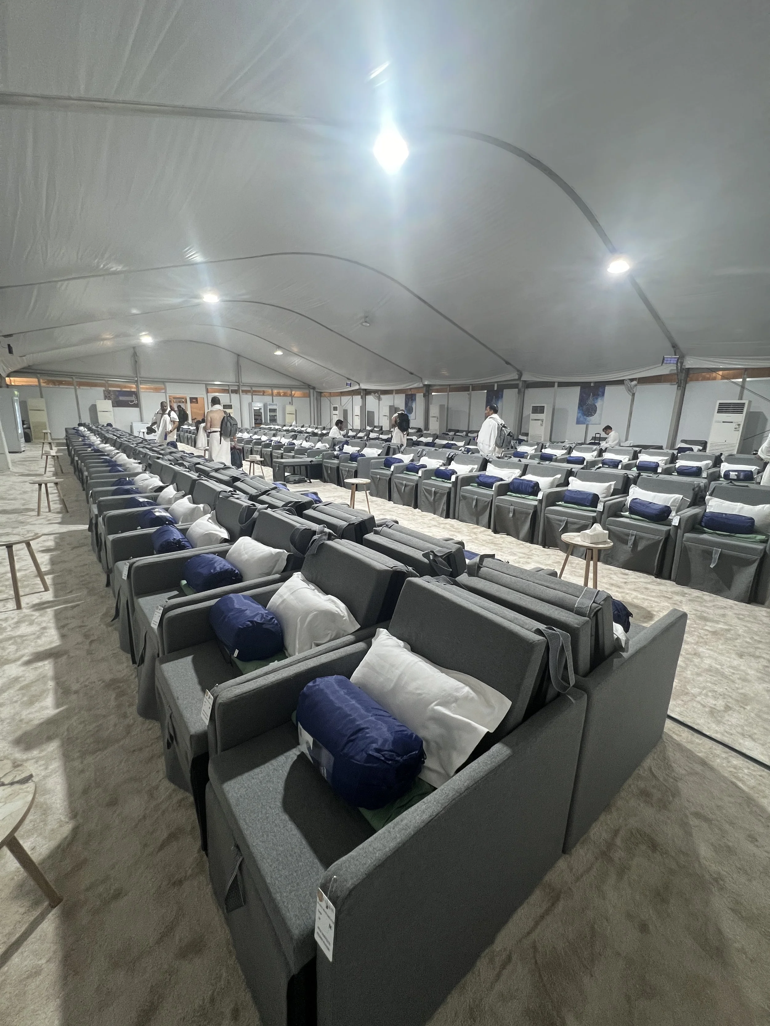 Mina camp accommodations at Majar Al Kabsh with rows of cots and chairs inside a tent.